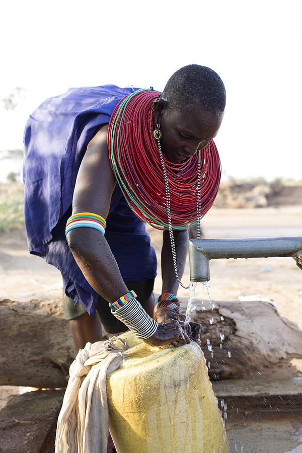 Women collecting clean water from borehole in desert. Samburu. Kenya. Photograph by Hugh Sitton