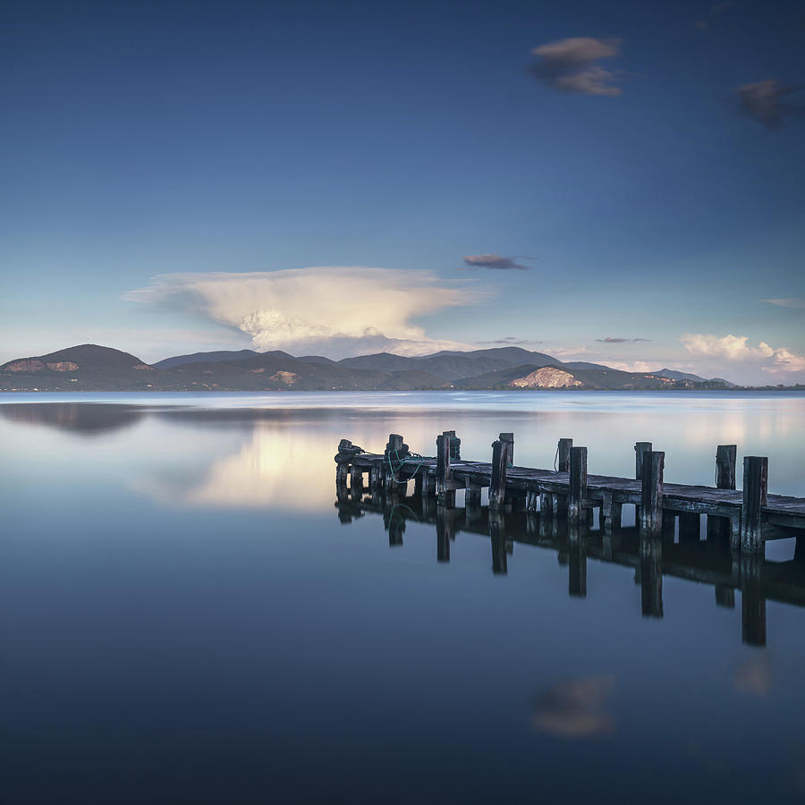Wooden pier or jetty on a blue lake sunset and sky reflection on #2 Photograph by Stefano Orazzini