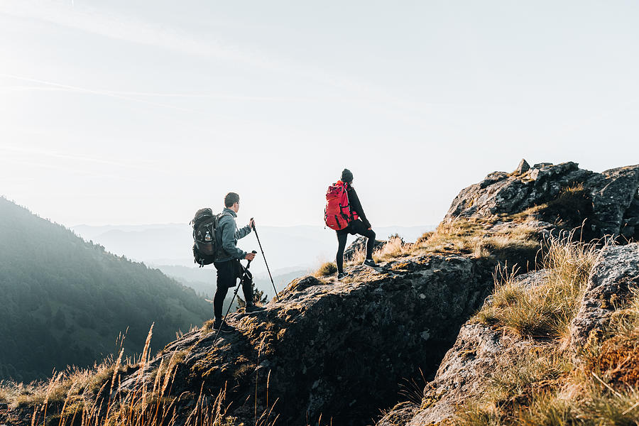 Young couple backpack up a mountain summit #2 Photograph by AscentXmedia