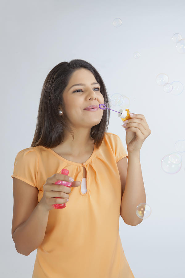 Young woman blowing soap bubbles #2 Photograph by Ravi Ranjan