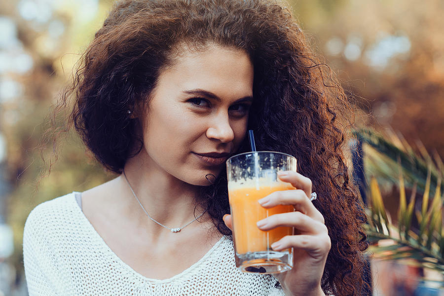 Young woman drinking orange juice #2 Photograph by Elisaveta Ivanova