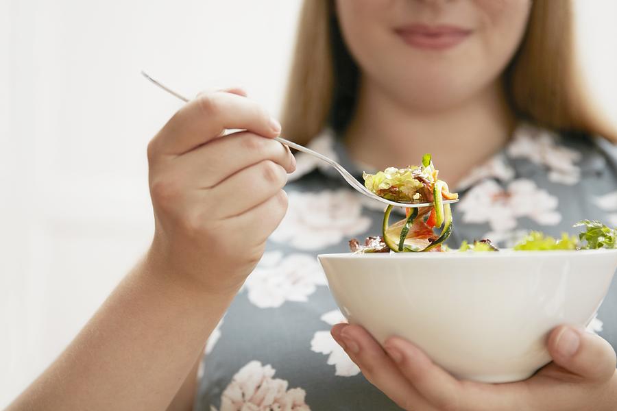 Young woman eating bowl of salad #2 Photograph by Science Photo Library