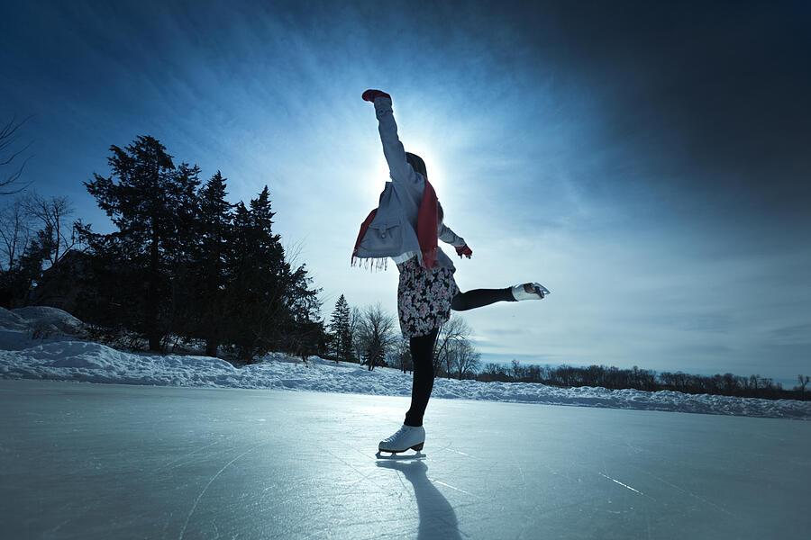 Young Woman Ice Skater Skating on Outdoor Winter Ice Rink #2 Photograph by YinYang