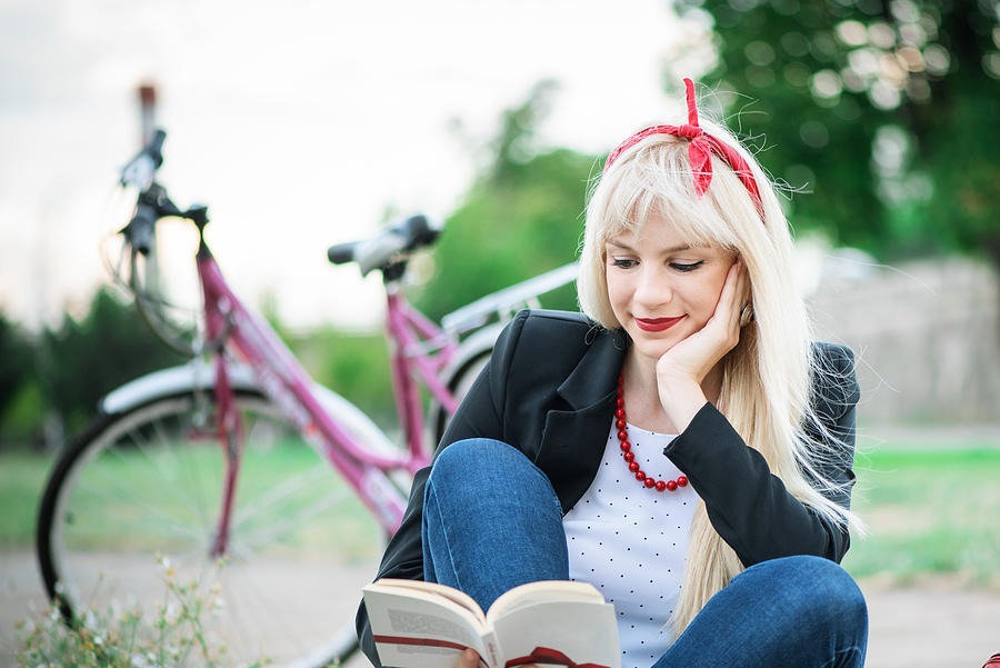 Young woman relaxing while reading a book at the park #2 Photograph by Emilija Manevska