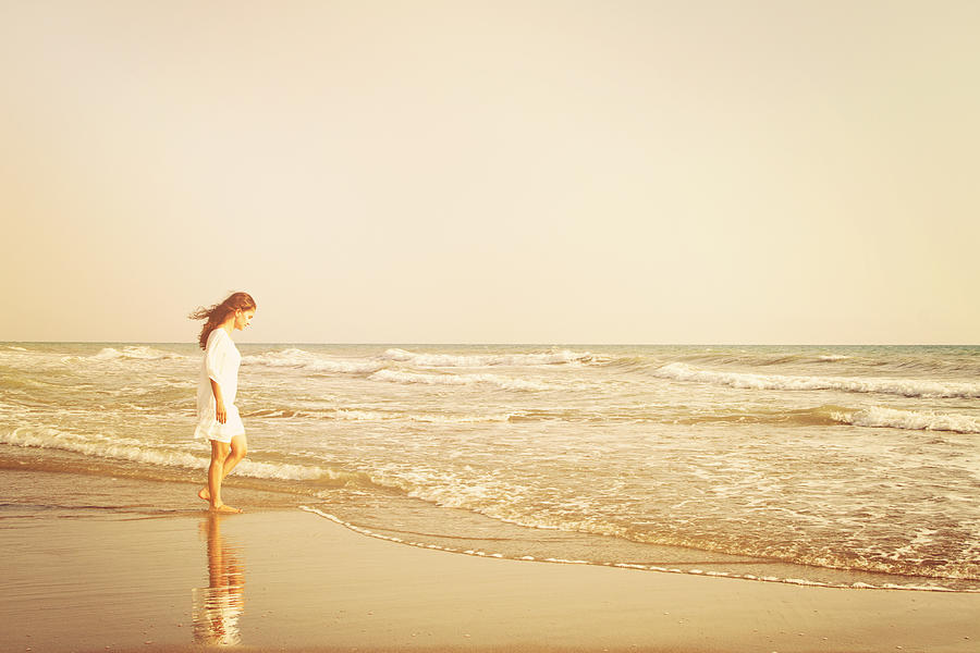 Young woman walking to the sun at beach. Freedom concept. Elegance at sunset. #2 Photograph by 1001Love