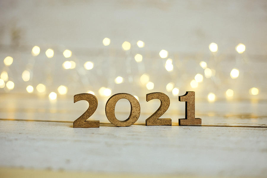 2021 New Year Number. Festive Card with blurred fairy lights and white shiny background. Photograph by Anna Blazhuk