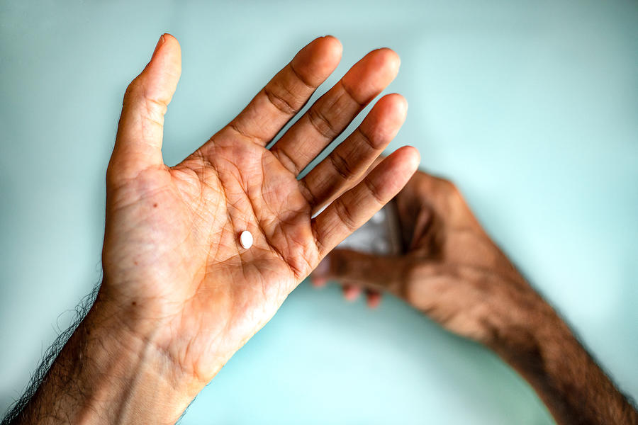 A mans hand holding a pill #3 Photograph by Photographer, Basak Gurbuz Derman