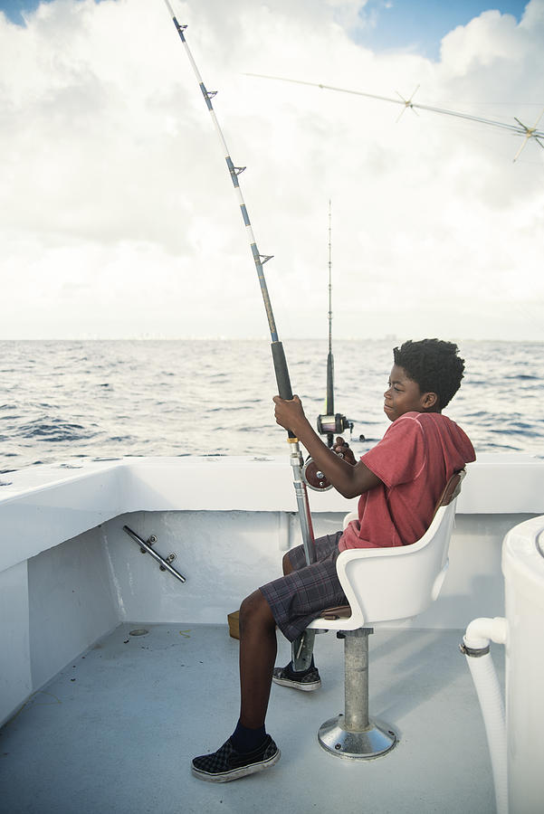 African-american boy on a sea fishing trip. #3 Photograph by Martinedoucet