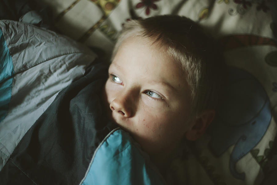 Boy lying in bed #3 Photograph by Johner Images
