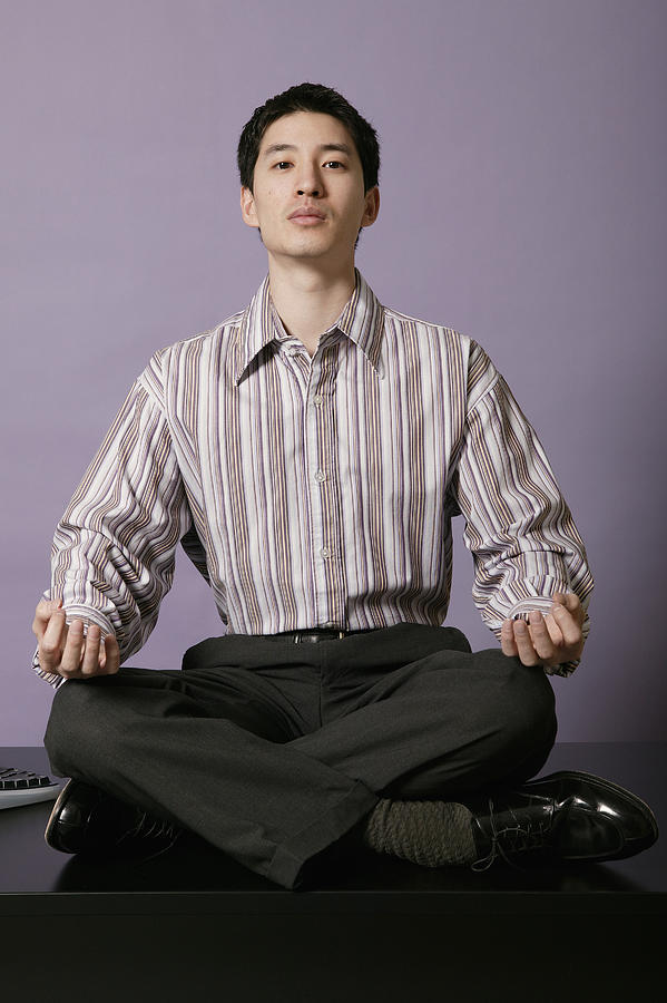 Businessman meditating on top of desk #3 Photograph by Comstock Images