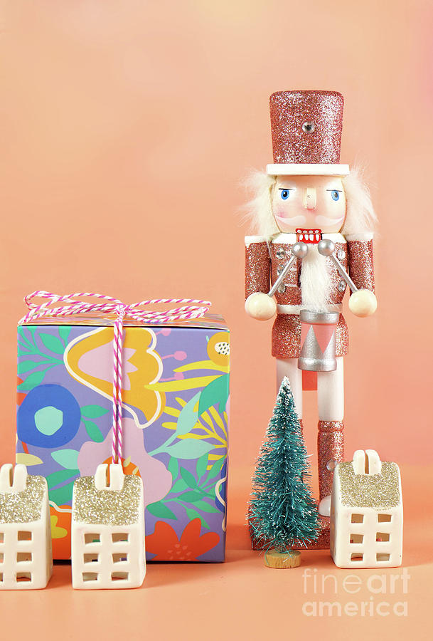 Christmas nutcracker ornaments and gifts against a modern coral background. #3 Photograph by Milleflore Images
