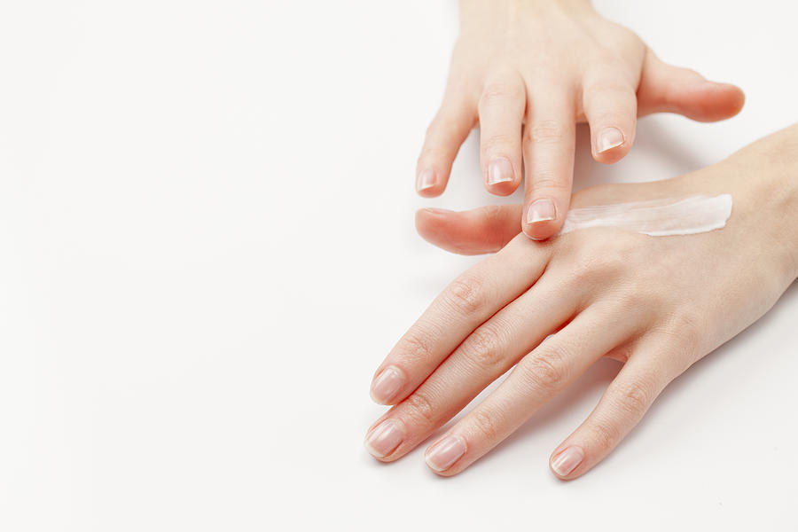 Close up of womans hands applying  moisturizer, studio shot #3 Photograph by Jan Scherders