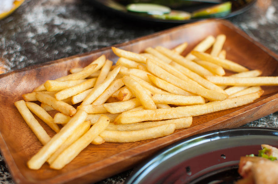 French fries on a wooden plate #3 Photograph by Karl Tapales