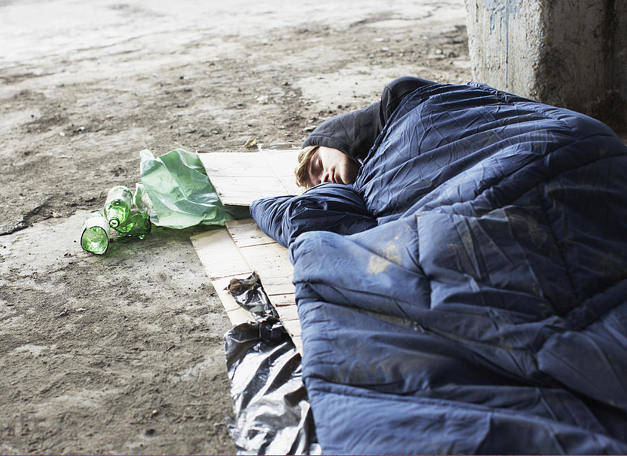 Homeless man sleeping in sleeping bag on cardboard #3 Photograph by Paul Bradbury
