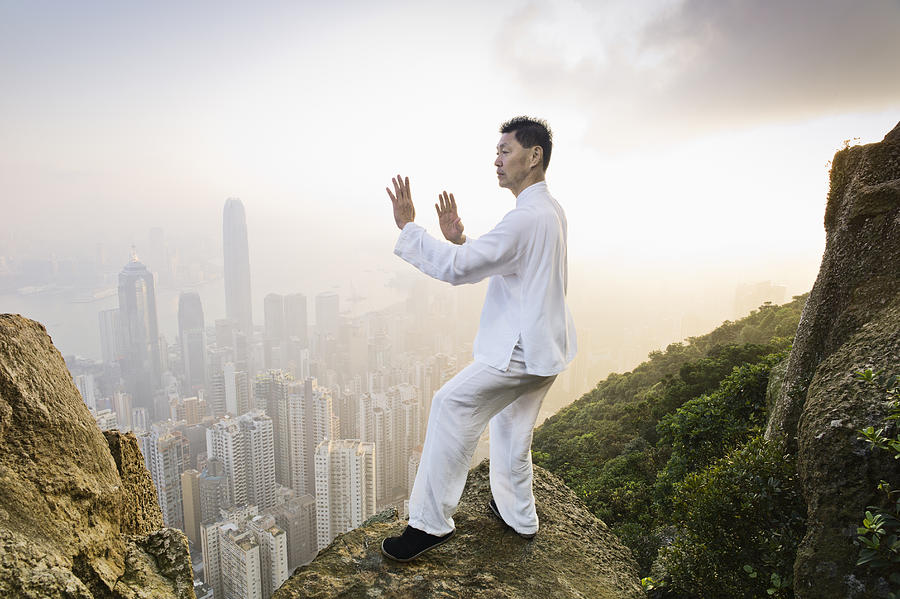Man practicing Tai Chi infront of skyline #3 Photograph by Martin Puddy