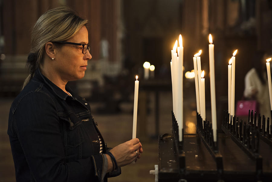 Mature woman lighting candles in church. #3 Photograph by Martinedoucet