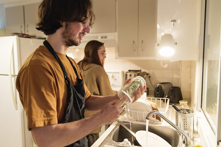 Millennial couple of students shared living doing chores. #3 Photograph by Martinedoucet