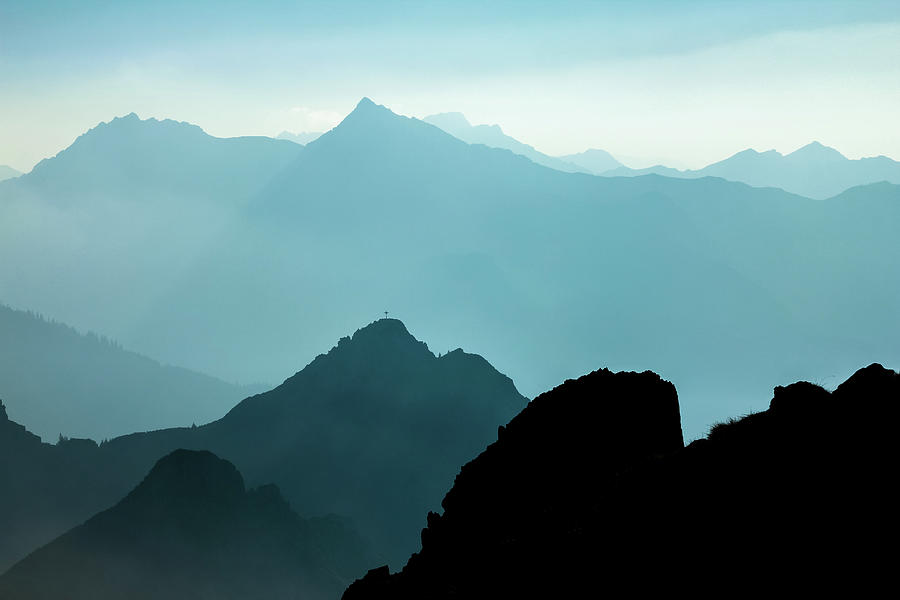 Spectacular blue and cyan mountain ranges silhouettes. Summit cr ...