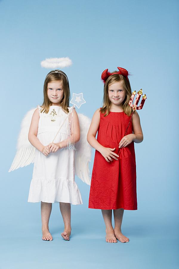 Twin girls dressed as an angel and devil #3 Photograph by Image Source