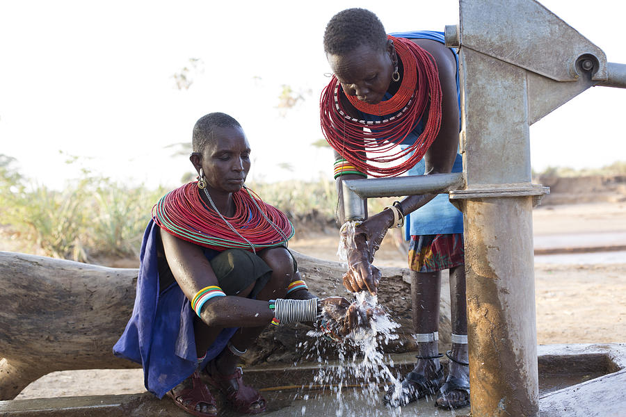 Women collecting clean water from borehole in desert. Samburu. Kenya. #3 Photograph by Hugh Sitton