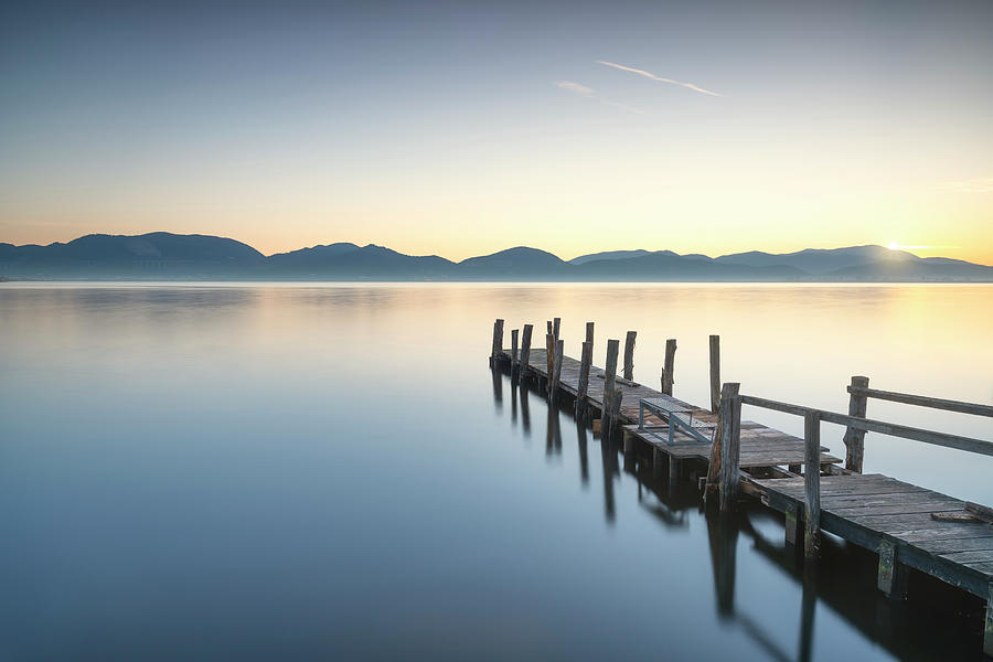 Wooden pier or jetty and lake at sunrise. Torre del lago Puccini Photograph by Stefano Orazzini