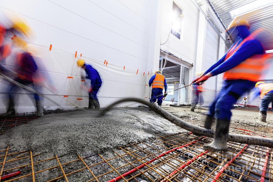 Workers do concrete screed on floor with heating in a new warehouse ...