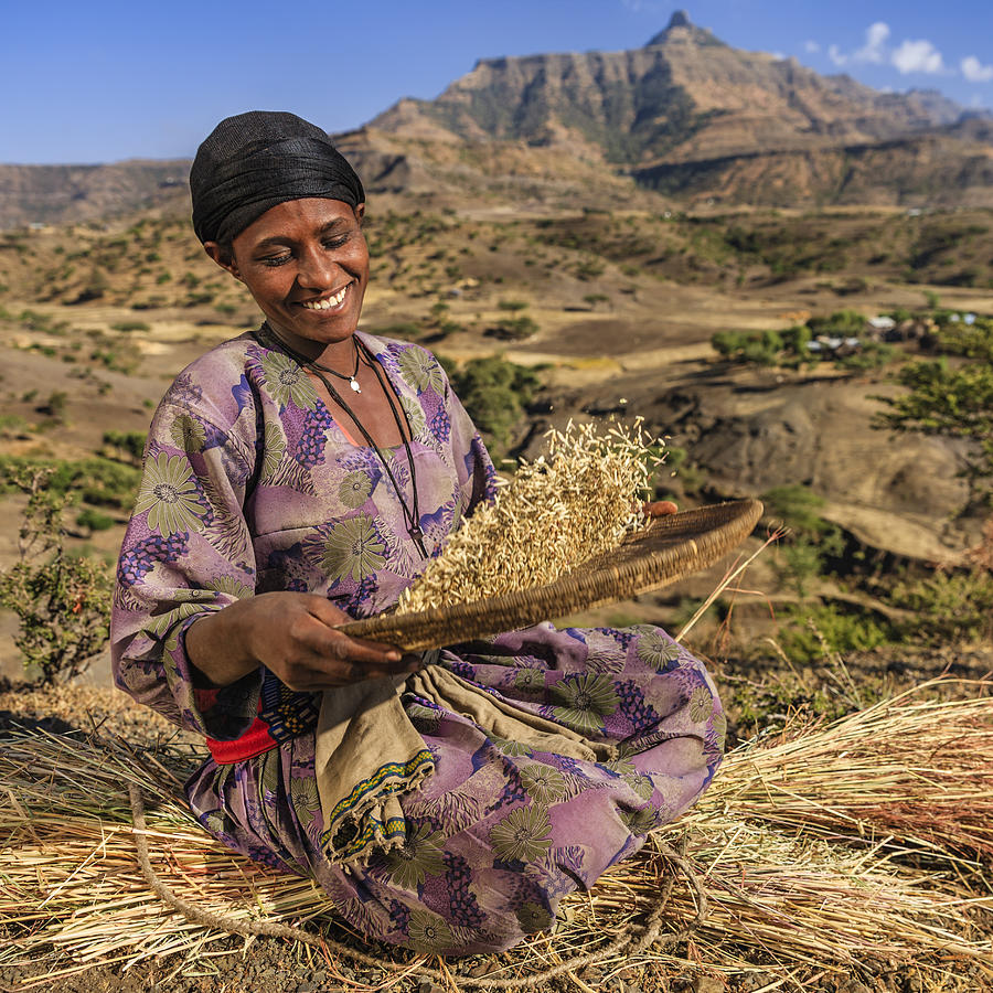 Young African woman is sifting the sorghum, East Africa #3 Photograph by Bartosz Hadyniak