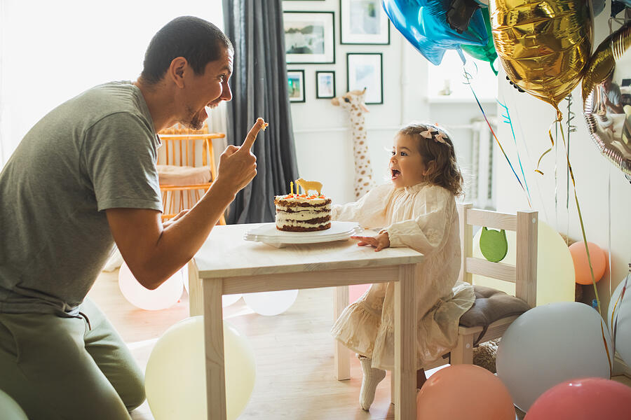 Young girl with father eating cake and having fun for celebreating her 2th years birthday. #3 Photograph by Anastasiia Krivenok