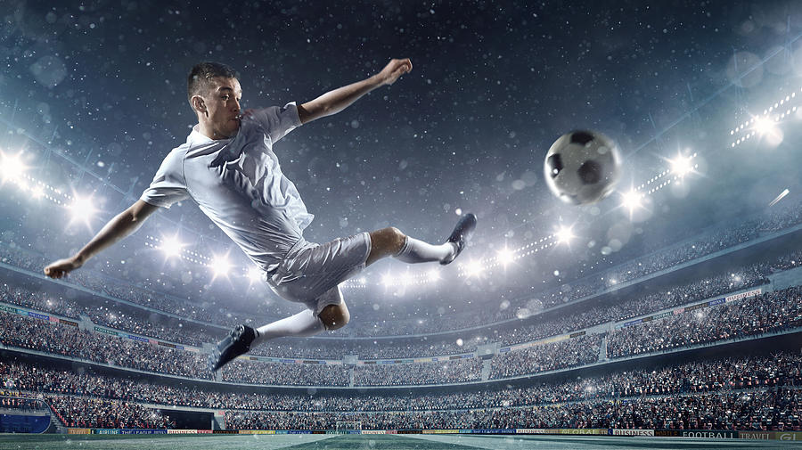 Soccer player kicking ball in stadium #32 Photograph by Dmytro Aksonov
