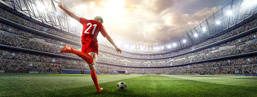 Soccer player kicking ball in stadium #35 Photograph by Dmytro Aksonov