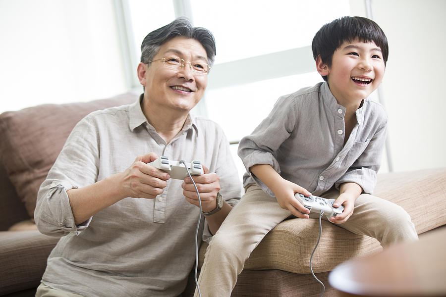 Cheerful grandfather and grandson playing video game #4 Photograph by Lane Oatey / Blue Jean Images