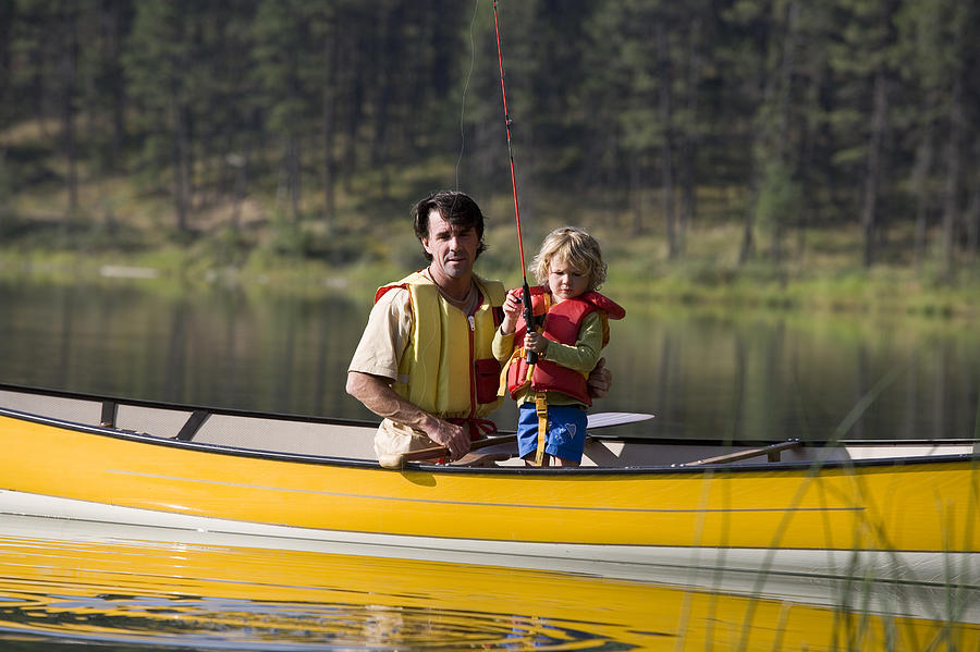Father and child fishing in a canoe #4 Photograph by Comstock Images