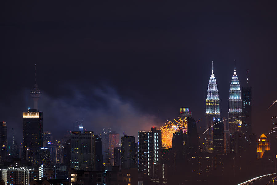 Fireworks explode near Malaysias landmark Petronas Twin Towers during New Year celebrations in Kuala Lumpur #4 Photograph by Shaifulzamri