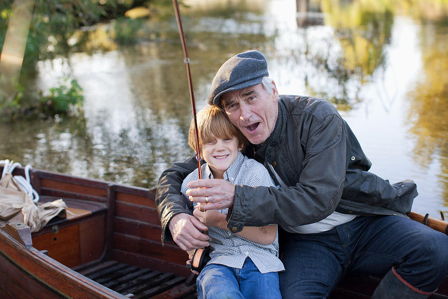 Grandfather and grandson fishing in boat #4 Photograph by Sam Edwards