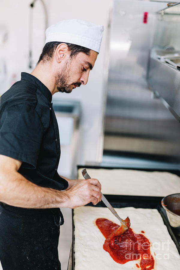 Italian Chef Pizzaiolo Putting Tomato Sauce On Pizza In Restaurant ...