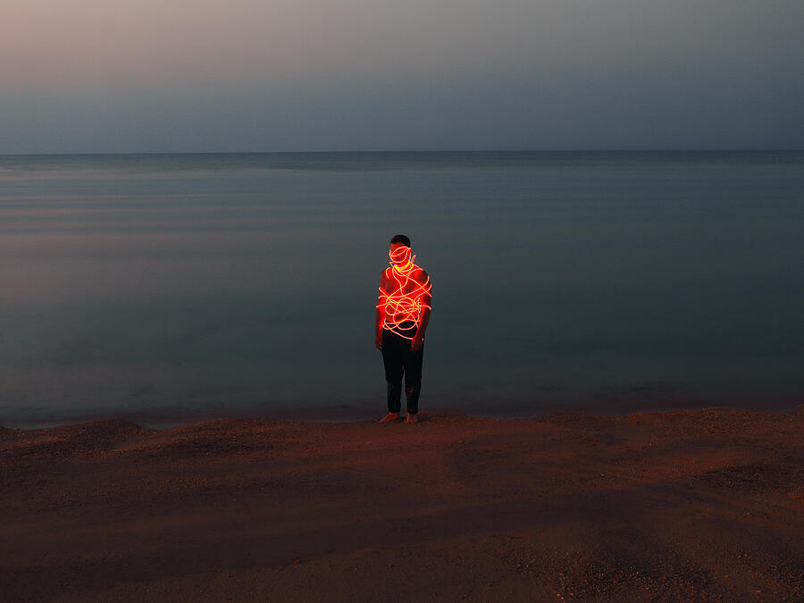 Man entangled with neon wires against sea background #4 Photograph by Vasilina Popova