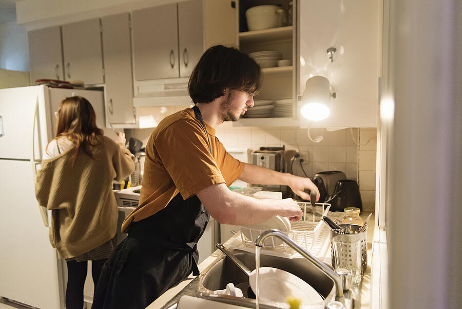 Millennial couple of students shared living doing chores. #4 Photograph by Martinedoucet