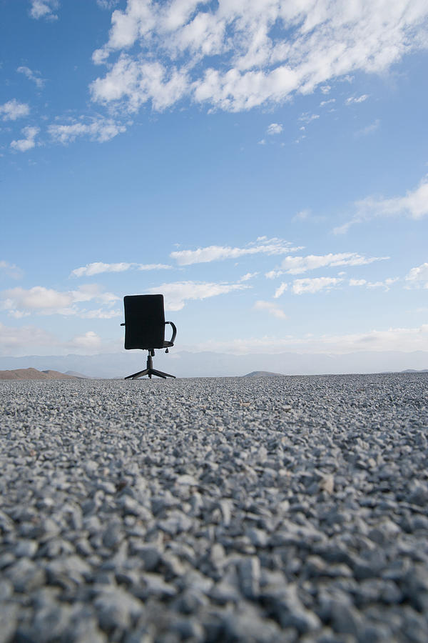 Office chair on a terrain full of pebbles #4 Photograph by Martin Barraud