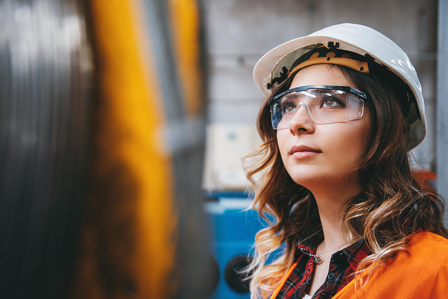 Portrait of young beautiful engineer woman working in factory building. #4 Photograph by Serts