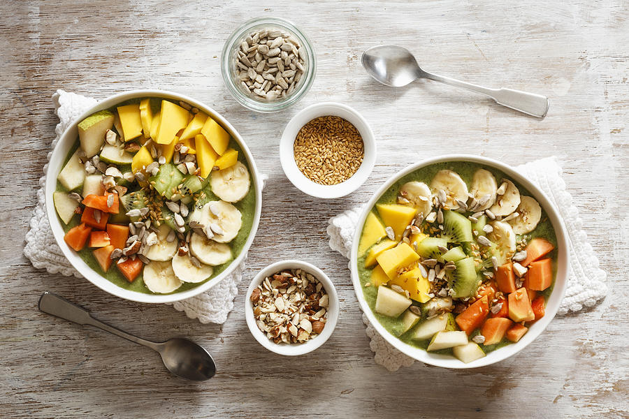 Smoothie bowl with different fruits, mango, papaya, kiwi, banana and pear and toppings, lineseeds, sunflower-seeds and nuts #4 Photograph by Westend61