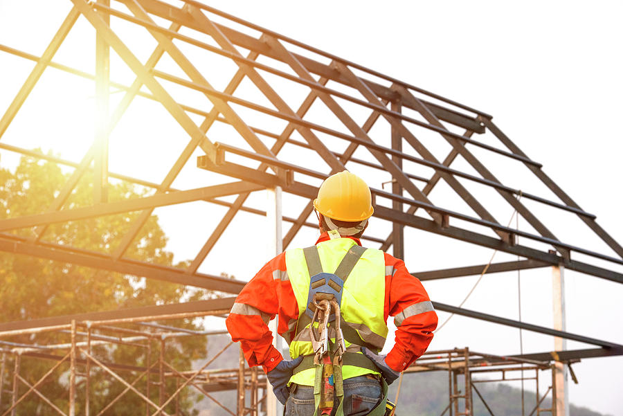 The construction worker supervises the construction of the roof Mixed ...