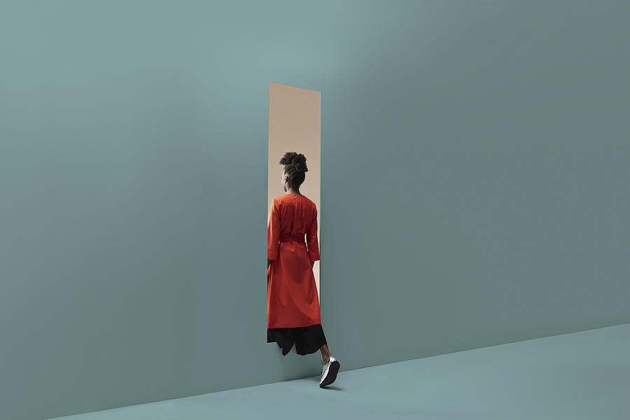 Woman walking into rectangular opening in coloured wall #4 Photograph by Klaus Vedfelt