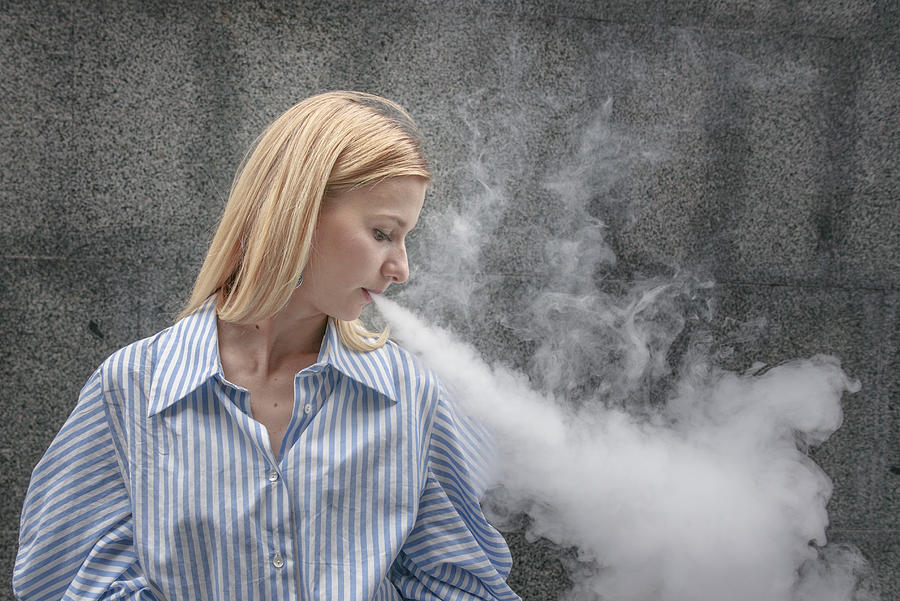 Young female smoking electronic cigarette #4 Photograph by Artem Hvozdkov