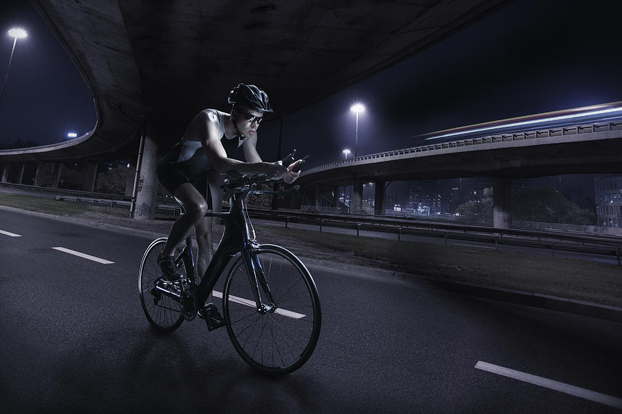 Cyclist riding at night in the city #5 Photograph by Stanislaw Pytel