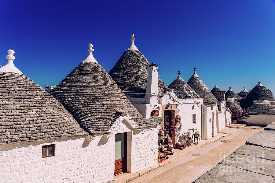 Houses Of The Tourist And Famous Italian City Of Alberobello, With Its Typical White Walls And Trulli Conical Roofs. Photograph
