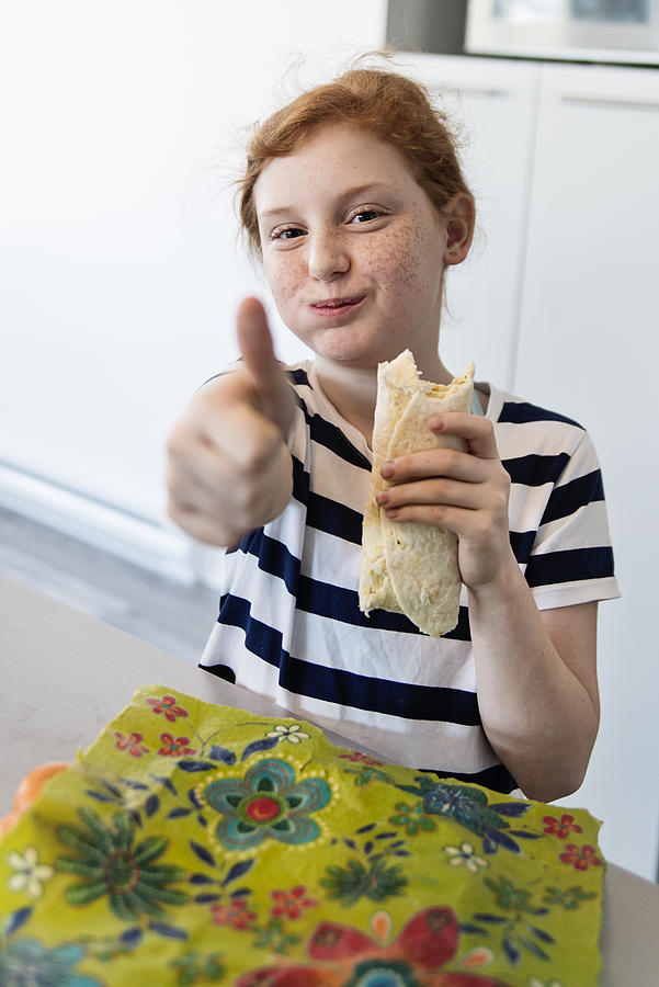 Preteen girl showing how to use eco-friendly food wrap. #5 Photograph by Martinedoucet