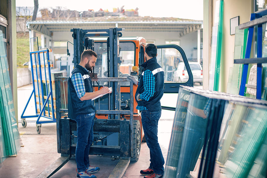 Workers in warehouse with forklift #5 Photograph by Bluecinema