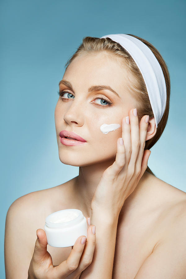 Woman applying moisturiser #6 Photograph by Image Source