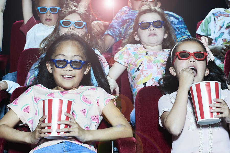 Group of children enjoying a movie at the cinema #7 Photograph by Flashpop