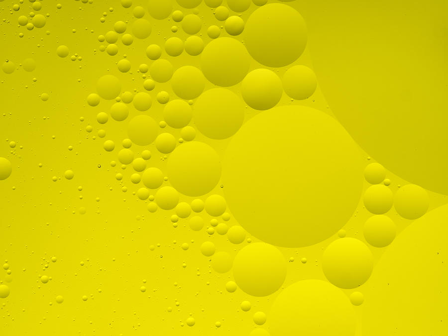 Full frame of the textures formed by the bubbles and drops of oil in the shape of circle floating on a yellow colors background #9 Photograph by Jose A. Bernat Bacete